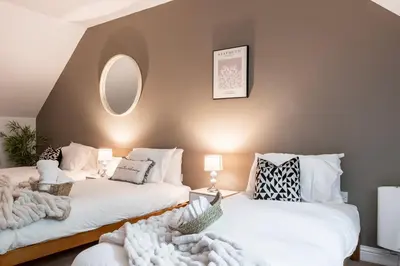 a living room with two beds and a mirror at Stylish 5Bedroom Getaway in Quiet Mildenhall Area in Mildenhall