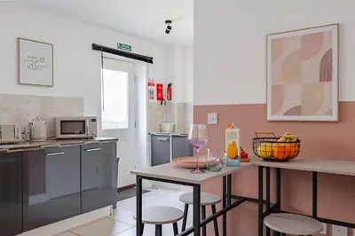 a kitchen with a table with two chairs and a counter with wine glasses at Stylish 5Bedroom Getaway in Quiet Mildenhall Area in Mildenhall