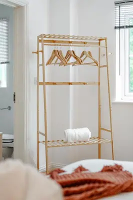 a wooden shelf with hangers in a room at Stylish 5Bedroom Getaway in Quiet Mildenhall Area in Mildenhall
