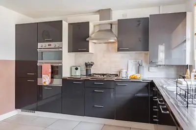 a kitchen with black cabinets and stainless steel appliances at Stylish 5Bedroom Getaway in Quiet Mildenhall Area in Mildenhall