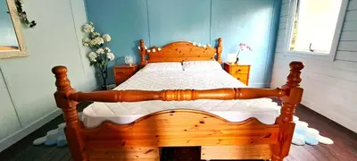 a bedroom with a wooden bed with a wooden frame at Lakeview Petting Pod in Chelmsford