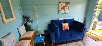 a blue couch with a pillow on a porch at Lakeview Petting Pod in Chelmsford