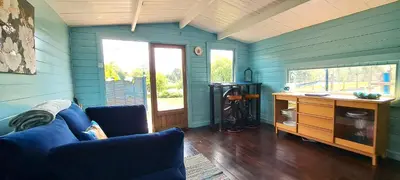 a living room with blue walls and a blue couch at Lakeview Petting Pod in Chelmsford
