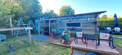 a play house with a playground and a table and chairs at Lakeview Petting Pod in Chelmsford