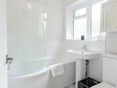 a white bathroom with a tub and a sink at Stylish 2-Bedroom Flat in Great Warley – Sleeps 6 Pass the Keys in Great Warley Street