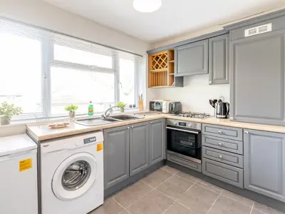 a kitchen with gray cabinets and a washer and dryer at Stylish 2-Bedroom Flat in Great Warley – Sleeps 6 Pass the Keys in Great Warley Street