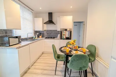 a kitchen with a table and chairs in a kitchen at Stylish Southend Stay in Southend-on-Sea