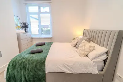 a bedroom with a bed with a green blanket on it at Stylish Southend Stay in Southend-on-Sea