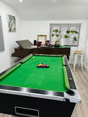 a pool table in a living room with at Hertford Home detached garden parking pet allowed in Hertford