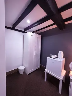 a bathroom with a toilet and a white cabinet at The Courtyard Lodge in Hitchin