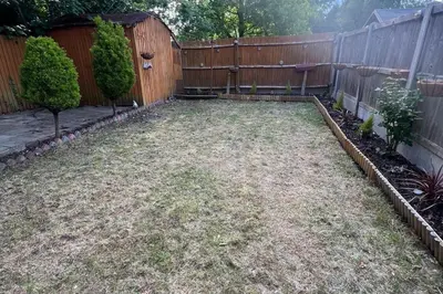 a backyard with a fence and a yard withgrass at 4-Bed Barnwell Retreat- Sleeps10 Garden & Parking in Stevenage