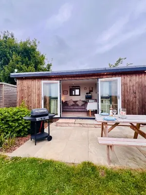 a backyard with a grill and a picnic table at Romantic Cabin Retreat on 50-Acre Suffolk Farm in Burgh