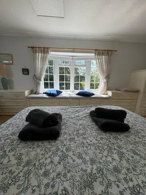 a bedroom with a large bed with two pillows on it at Sherrington Cottage 1 minute walk to Frintons blue flag beach Sleeps up to 8 in Frinton-on-Sea