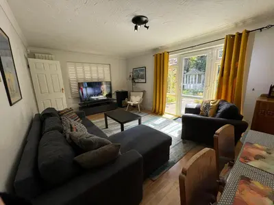 a living room with a couch and a tv at Sherrington Cottage 1 minute walk to Frintons blue flag beach Sleeps up to 8 in Frinton-on-Sea