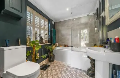 a bathroom with a toilet and a tub and a sink at A Beautiful Country Cottage in Waldringfield