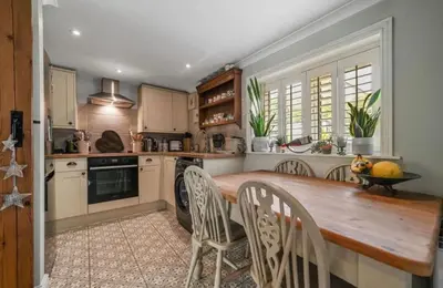 a kitchen with a wooden table and chairs at A Beautiful Country Cottage in Waldringfield