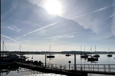 a dock with boats in a body of water at A Beautiful Country Cottage in Waldringfield