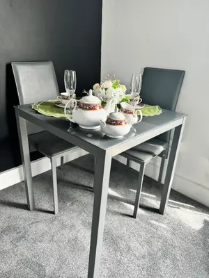 a table with two chairs and a tea set on it at Essex Dungeon Suite in Heybridge