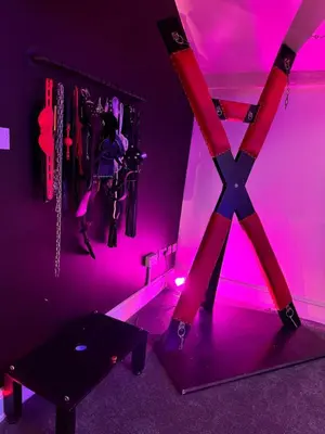 a room with pink lighting and a table in it at Essex Dungeon Suite in Heybridge