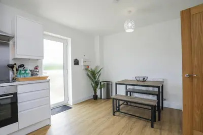 a kitchen with a table and a stool in a room at 8 Iris Cottage 4-BR Coastal Home in Suffolk in Wenhaston