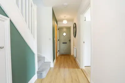 a hallway of a home with white walls and wood floors at 8 Iris Cottage 4-BR Coastal Home in Suffolk in Wenhaston