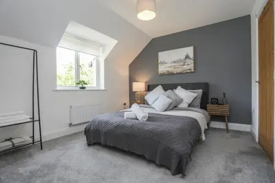 a bedroom with a large bed and a window at 8 Iris Cottage 4-BR Coastal Home in Suffolk in Wenhaston