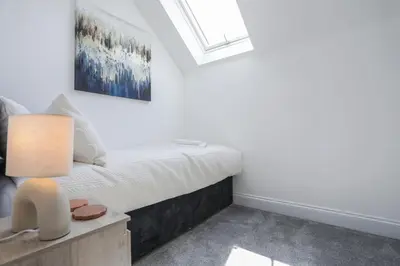 a bedroom with a bed and a window at 8 Iris Cottage 4-BR Coastal Home in Suffolk in Wenhaston