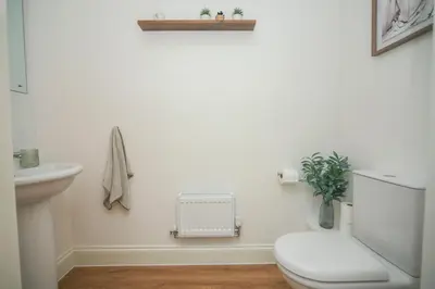 a white bathroom with a toilet and a sink at 8 Iris Cottage 4-BR Coastal Home in Suffolk in Wenhaston