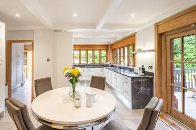 a kitchen with a round table and chairs at Large indoor swimming pool in Thetford Forest - The Pool House in Downham