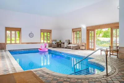 a swimming pool in a house with a swimming poolvisorvisor at Large indoor swimming pool in Thetford Forest - The Pool House in Downham