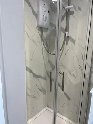 a shower stall with a glass shower door at Dolly Studio in Colchester