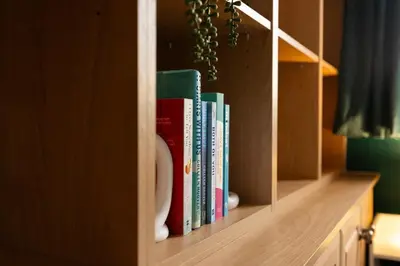 a book shelf with a bunch of books on it at Cambridge House near Addenbrookes, station and parking! in Shelford