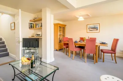 a dining room and living room with a table and chairs at 3 Bell Lodge - near Thorpeness Country Club and the beach - Aldeburgh Coastal Cottages in Thorpeness