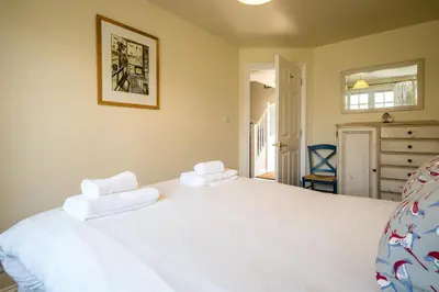 a bedroom with a white bed with towels on it at 3 Bell Lodge - near Thorpeness Country Club and the beach - Aldeburgh Coastal Cottages in Thorpeness
