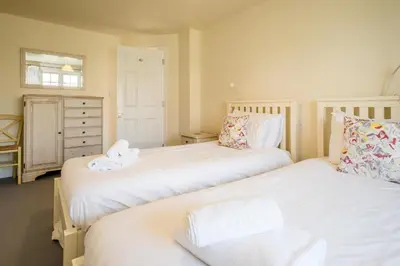a bedroom with two beds and a dresser at 3 Bell Lodge - near Thorpeness Country Club and the beach - Aldeburgh Coastal Cottages in Thorpeness