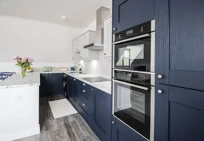 a kitchen with blue cabinets and a stove top oven at Gad About in Woodbridge