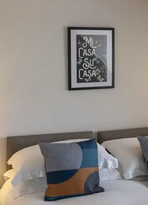 a bedroom with a bed with a picture on the wall at Gad About in Woodbridge