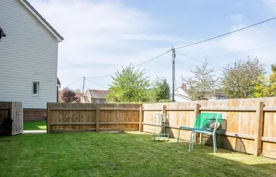 a backyard with a fence and a table and chairs at Gad About in Woodbridge