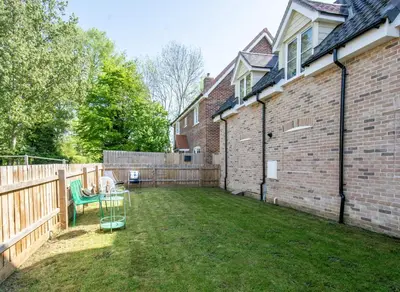 a backyard with a table and a fence and a building at Gad About in Woodbridge