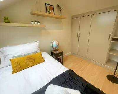 a bedroom with a white bed with a yellow pillow at Stylish 2 bed apartment - easy walk to Addenbrookes in Cambridge