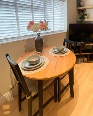 a dining room table with a vase of flowers on it at Stylish 2 bed apartment - easy walk to Addenbrookes in Cambridge