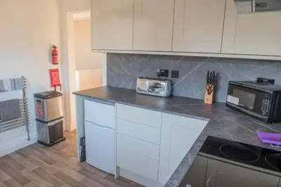 a kitchen with white cabinets and a microwave at Toothbrush Apartments - Ipswich East - Cauldwell Ave in Ipswich