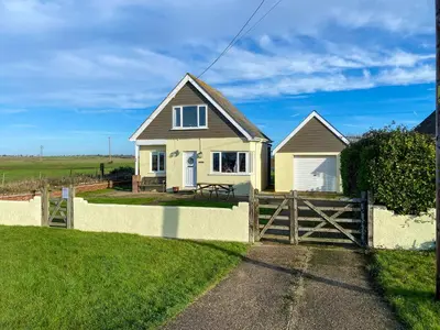 a house with a wooden fence in front of it at Humperdink in Saint Osyth