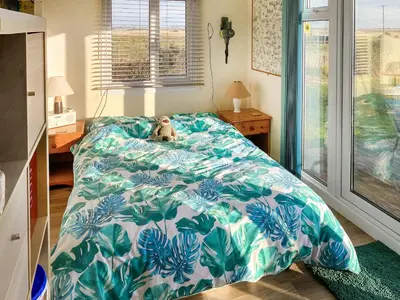 a teddy bear sitting on a bed in a bedroom at Humperdink in Saint Osyth