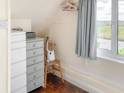 a bedroom with a dresser and a window at Humperdink in Saint Osyth