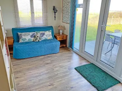 a blue chair with a teddy bear on it in a living room at Humperdink in Saint Osyth