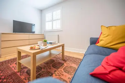 a living room with a blue couch and a table at Goldfinch, Leiston in Leiston
