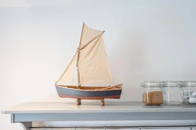 a small sail boat on a shelf with jars at Goldfinch, Leiston in Leiston