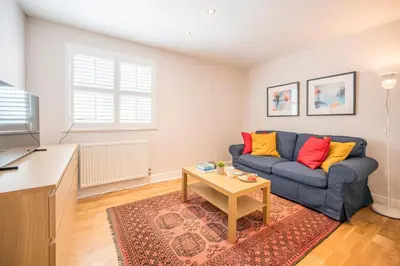 a living room with a blue couch and a table at Goldfinch, Leiston in Leiston