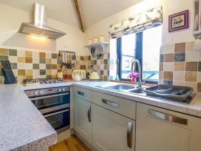 a kitchen with a sink and a stove at The Kiln in Harleston